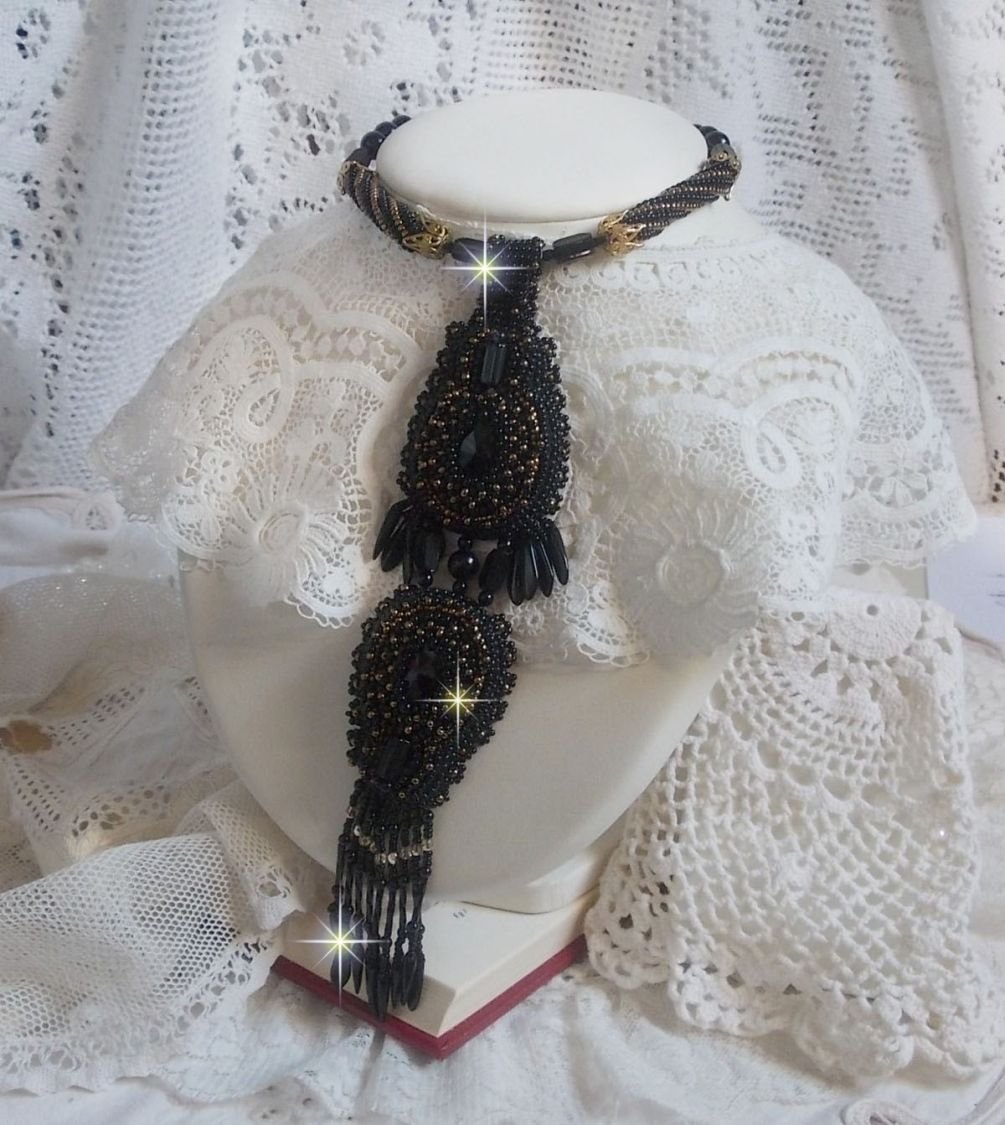 Pendentif Habit Noir pour un style Vintage est brodé avec une pierre de Gemme : l’Onyx Noir à laquelle s’ajoute des cristaux, dagues, perles, facettes et rocailles en Verre. Belle harmonie !