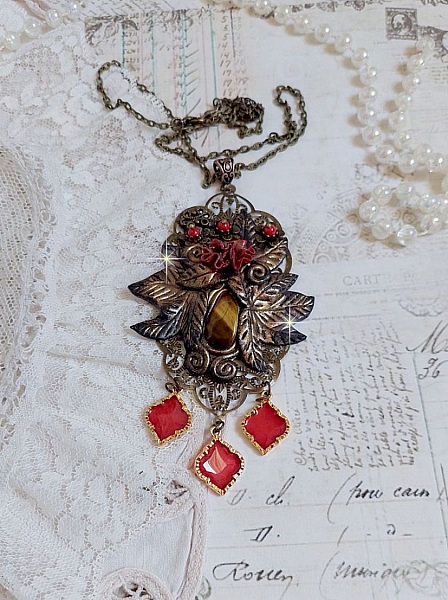 Pendentif M&eacute;lodie avec un cabochon &OElig;il de tigre orn&eacute; de perles en Jade Rouge vein&eacute; de Noir sur fleurs 5 p&eacute;tales et estampes mont&eacute;s sur une cha&icirc;ne bronze. Les pendants sont en r&eacute;sine &eacute;poxy Rouge
