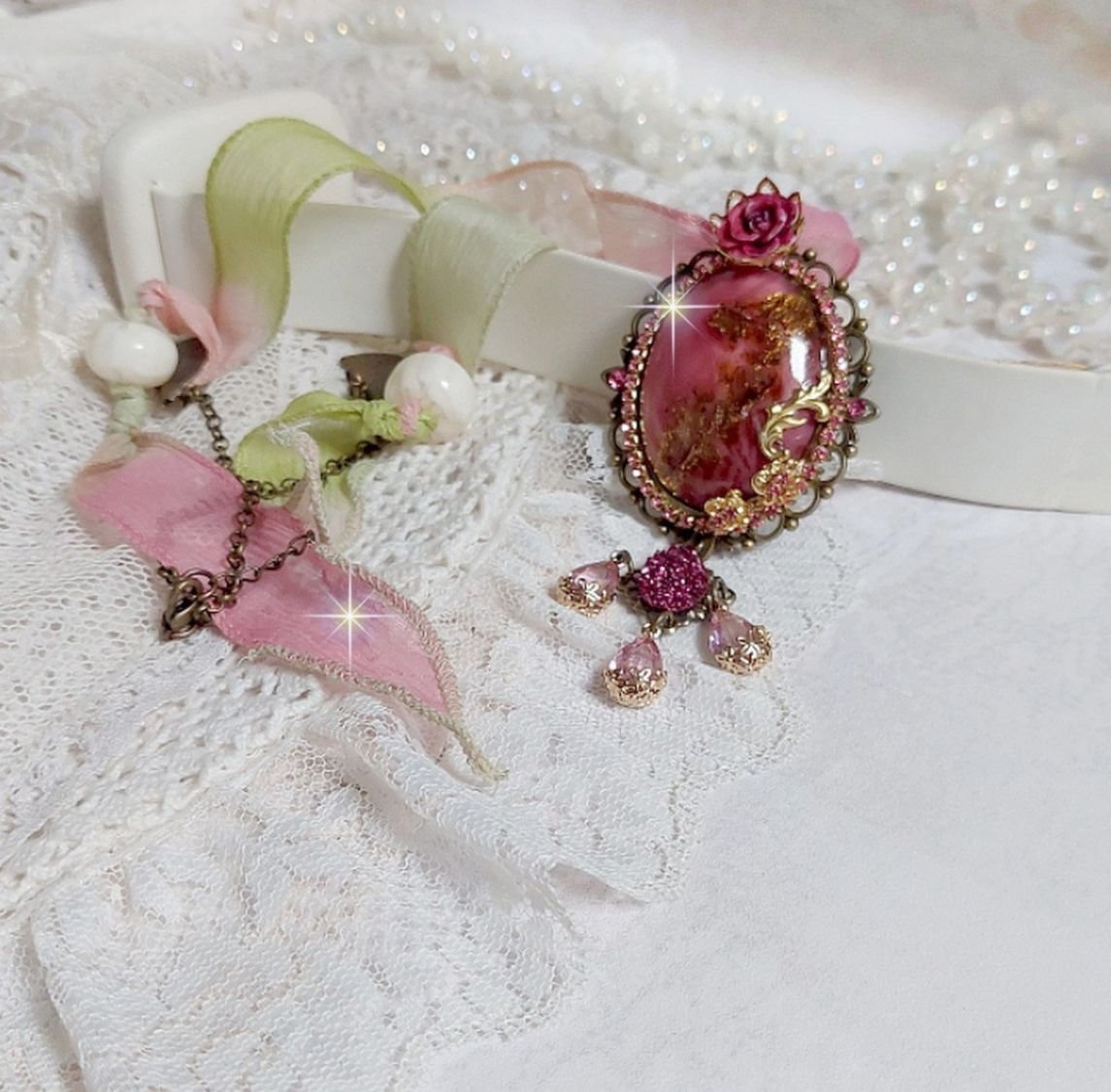 Pendentif Pampelone Fuchsia Haute Couture avec un cabochon artisanal et feuilles d’or, orné de strass, cristaux Roses, rose en résine, breloques, entretoises dentelles, Murano et ruban de soie