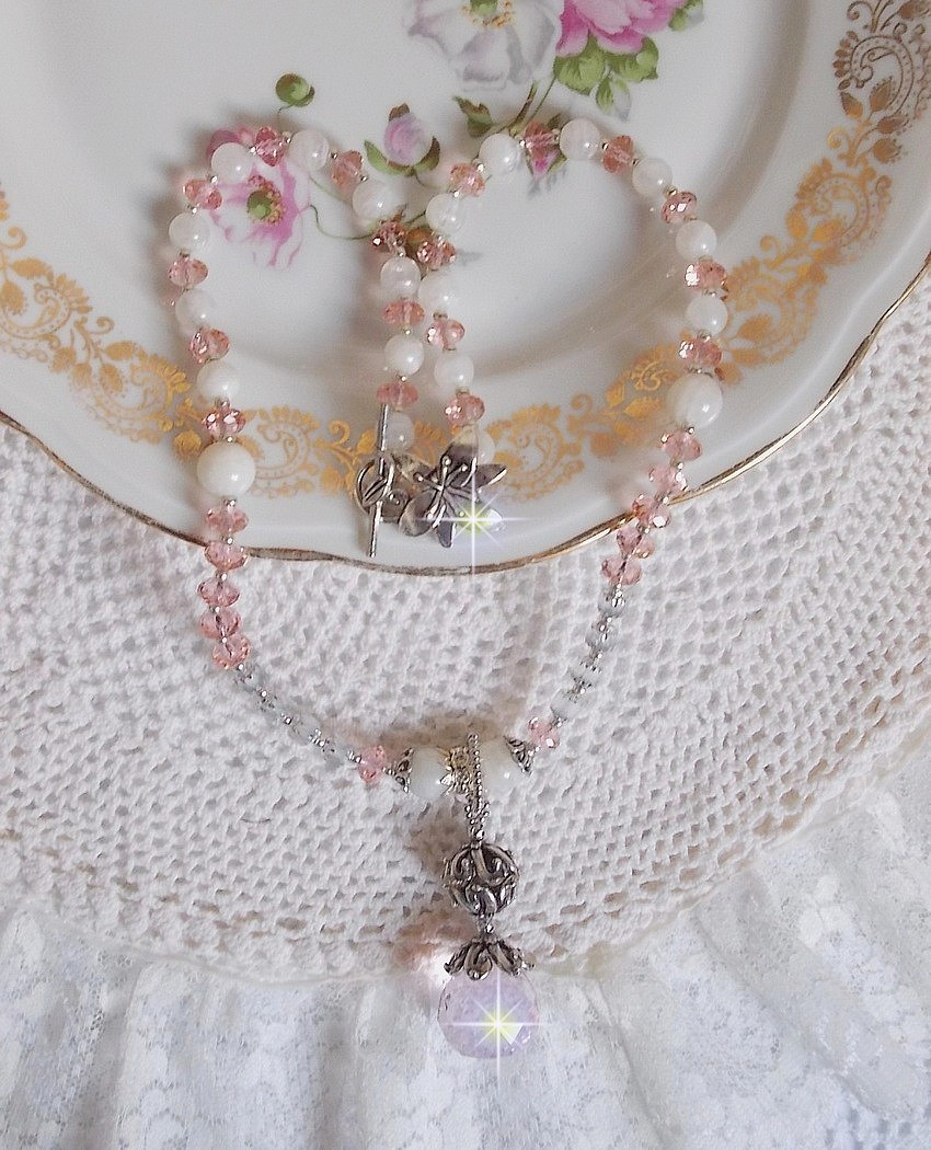 Pendentif Rose Irisé monté avec des perles rondes aplaties en cristal, des perles de gemme : la pierre de lune, des coupelles dômes, une perle d’espacement strassée, perles lisses et filigranées
