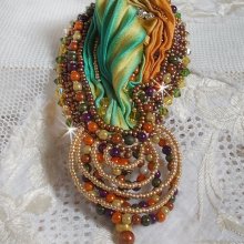 Broche Lune Vénitienne brodée avec un ruban de soie orange, vert et jaune, cristaux, : toupies et chatons. S’ajoute à l’ensemble des perles magiques et rocailles sur une broche Doré 